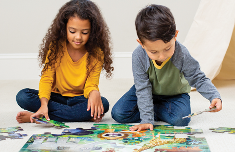 Two children assembling colorful Crocodile Creek puzzles