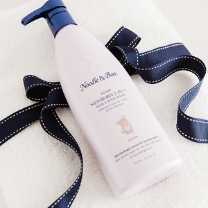 Noodle & Boo baby lotion presented with a navy ribbon